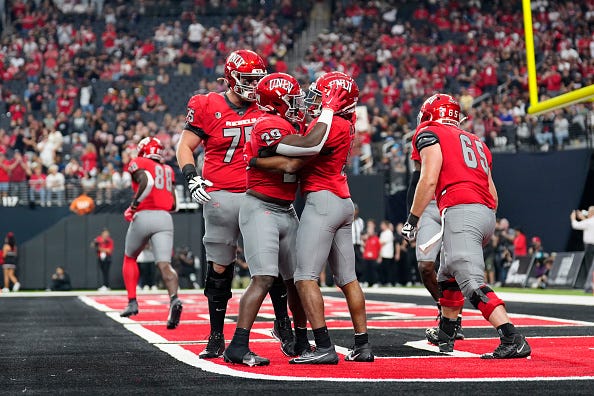 Vincent Davis Jr. #5 of the UNLV Rebels celebrates with this teammates following his touchdown in the first half of the game against the Hawaii Warriors at Allegiant Stadium on September 30, 2023
