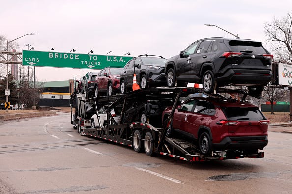 A car hauler carries Toyota RAV4 vehicles as it enters to cross the Ambassador Bridge in Windsor, Ontario to go to Detroit, Michigan on Monday, February 3, 2025