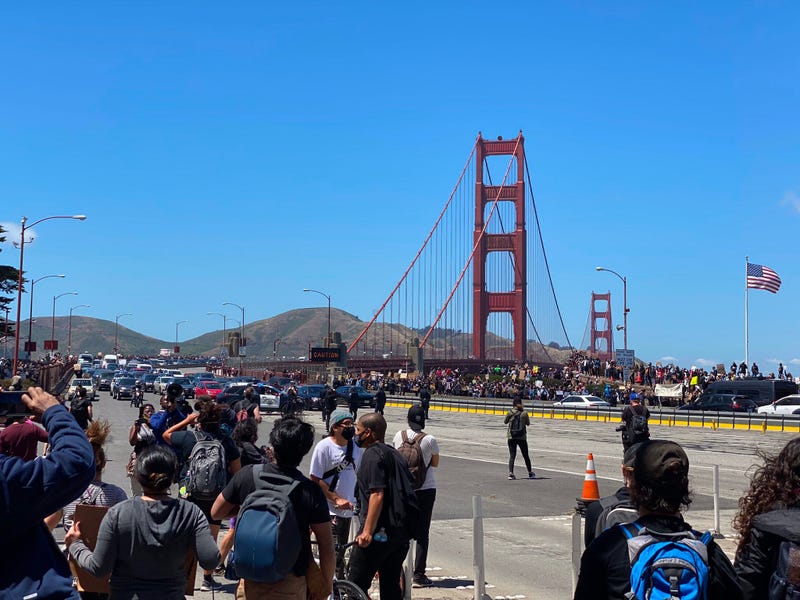 Black Lives Matter protesters march across and on to the roadway at the Golden Gate Bridge.