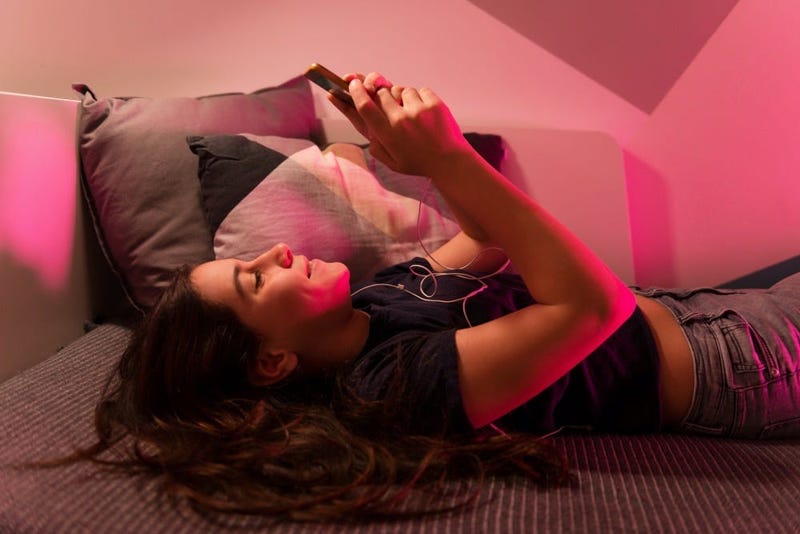 girl texting on phone in bed