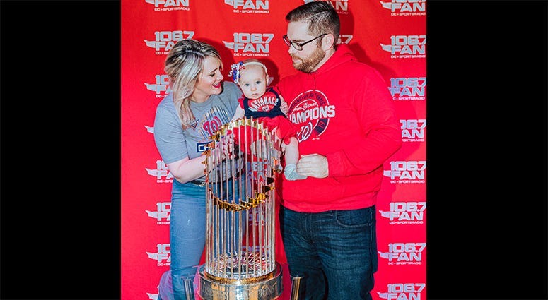 106.7 The Fan host Grant Paulsen and family pose with the World Series trophy