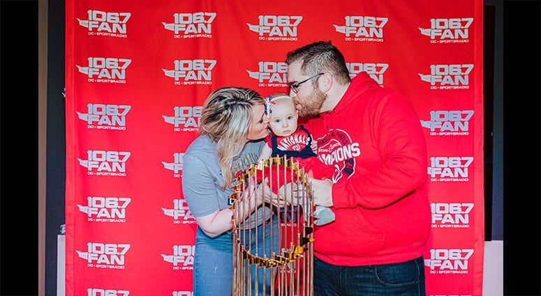 106.7 The Fan host Grant Paulsen and family pose with the World Series trophy