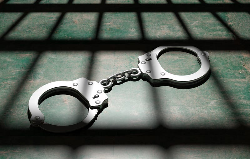Jail bars and metal handcuffs on the floor