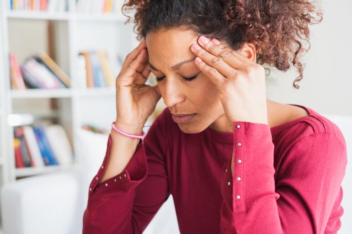 Woman with head in hands suffering a headache