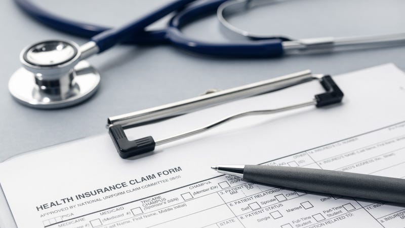 Health Insurance claim form and stethoscope on desk