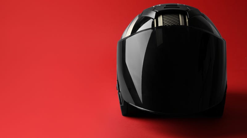 Modern motorcycle helmet with visor on red background - stock photo