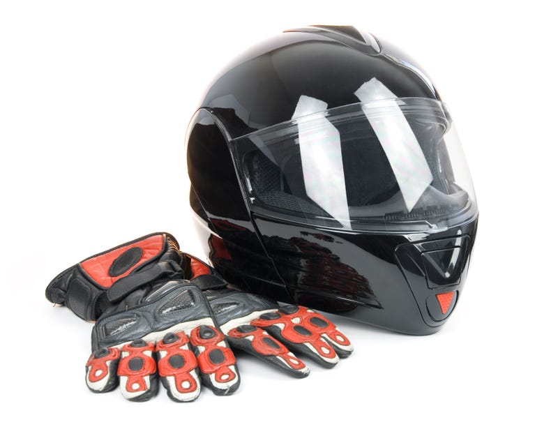 Black, shiny motorcycle helmet and leather biker gloves