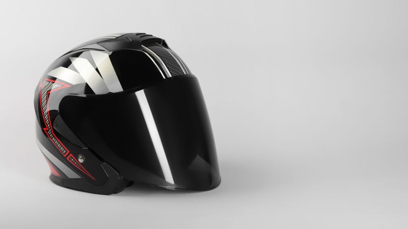 Motorcycle helmet with visor on light grey background - stock photo