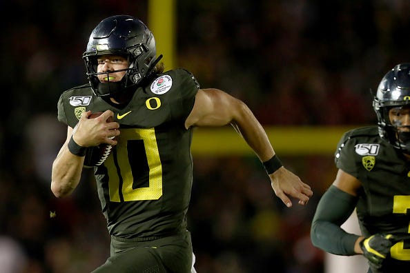 Oregon QB Justin Herbert rushes with the ball. 