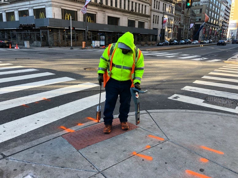 Errol Ray outside spraying paint in Center City on a frigid Monday afternoon.