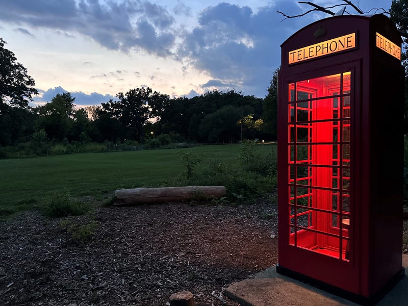 Bright red phone booth along golf course