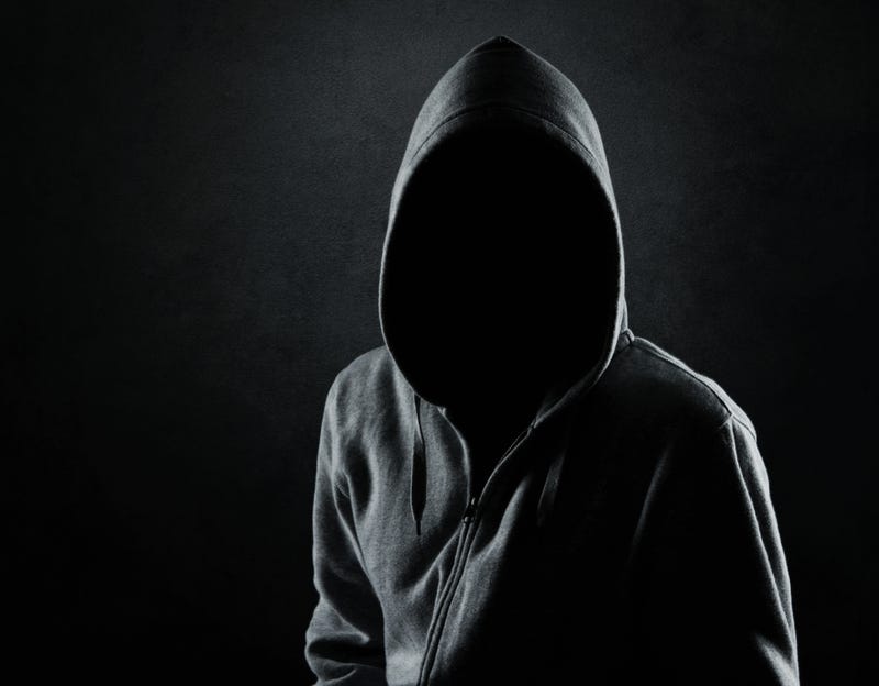 person in shadows wearing hood