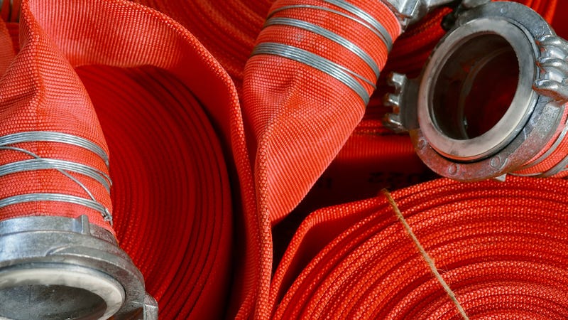 View of many twisted red fire hoses close-up