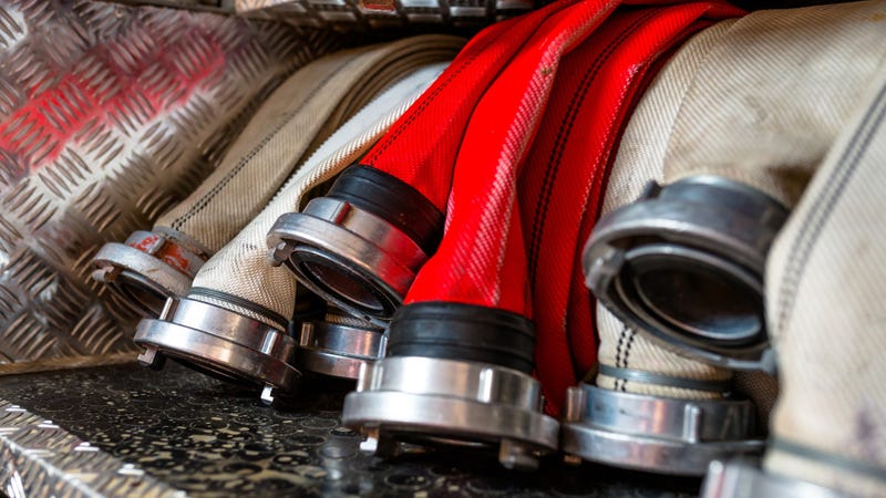 Rolled fire hoses, arranged in rows - stock photo