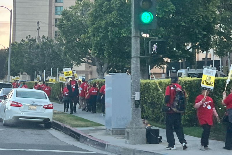 picketers on sidewalk outside hotel