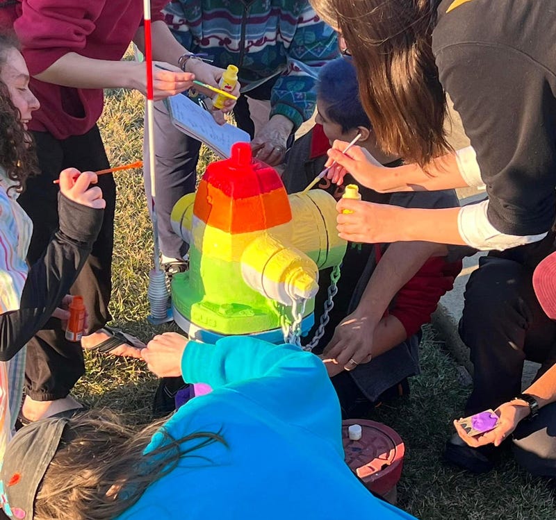 people painting a fire hydrant