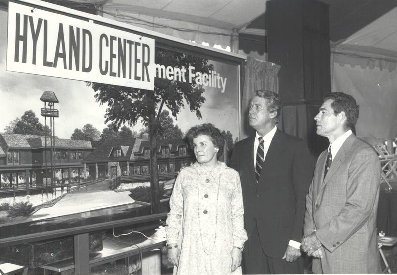 People stand in front of the Robert Hyland Center