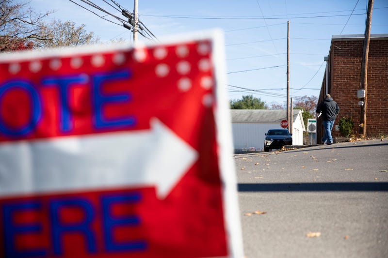 A sign urging people to "vote here" on Election Day 2022.