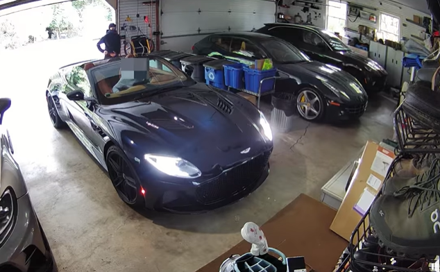 A masked man standing by the Aston Martin that was carjacked on Sunday. 