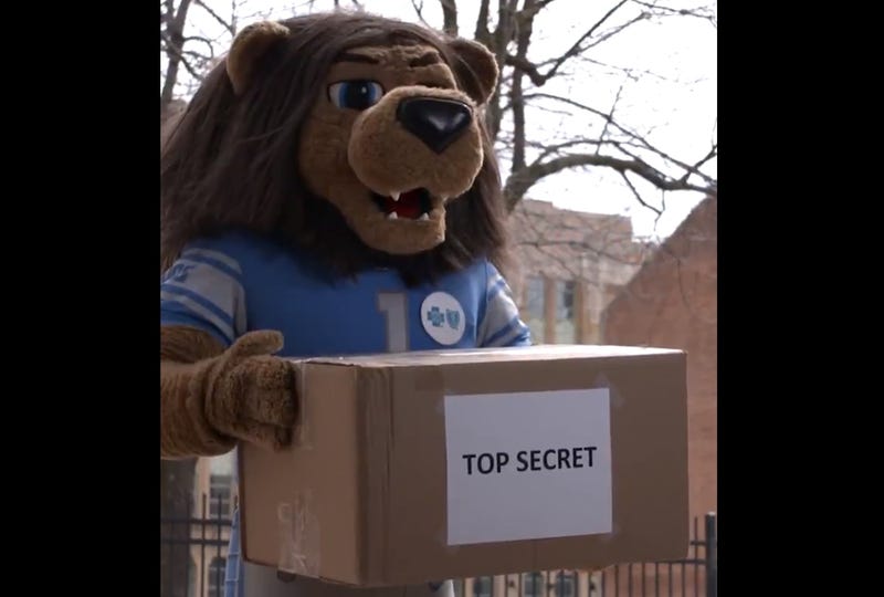 The fans want to know — what is in the box marked "top secret" that Rory the Lion was seen holding on the Detroit Lions' social media page the other day?