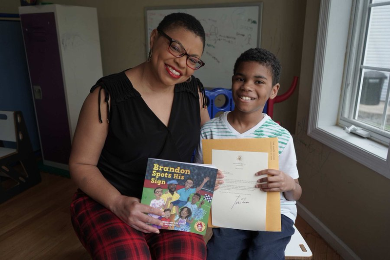 Sheletta Brundidge (L) and her son Brandon Brundidge pose with the children's book she wrote for him and to raise awareness for autism.