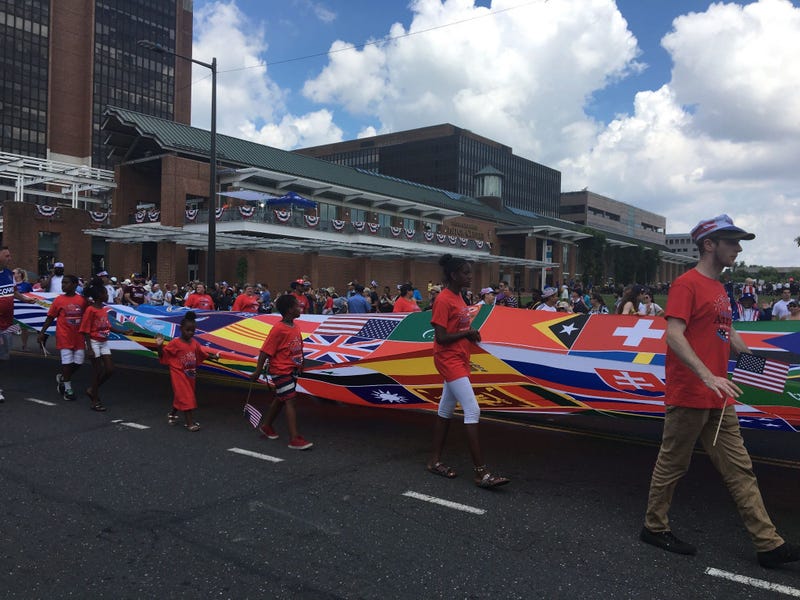 A banner representing the flags of the world marches by in the 2019 Independence Day Parade.