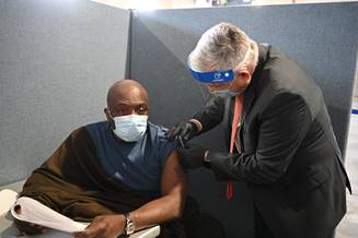 Dr. Richard Stone, Acting Under Secretary for Health, Veterans Health Administration, (right) administers a COVID-19 vaccine to a New York-area veteran. Dr. Stone recently visited a mass vaccination clinic in Yonkers, N.Y. as part of VA's Fourth Mission activities.