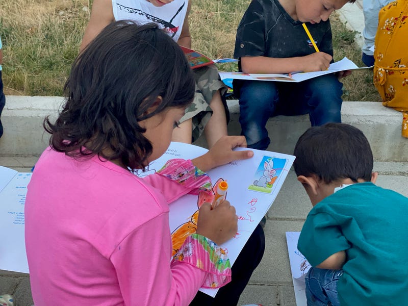 an Afghan girl colors after getting processed and checked in in Albania. Spirit of America is supporting the food, shelter, medical, and basic needs of 121 Afghans in Albania.