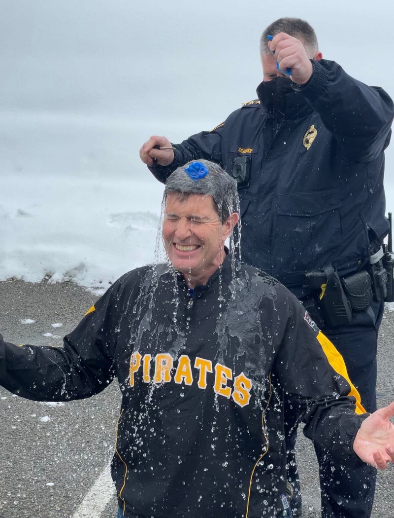 Pittsburgh Police Chief Scott Schubert pops balloon full of cold water over Rick Dayton's head in Polar Pop Challenge