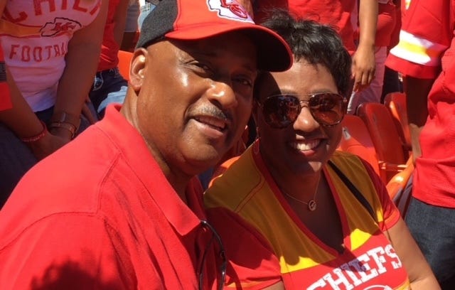 Ed and Donna Morris at a Chiefs game, both wearing Chiefs gear.