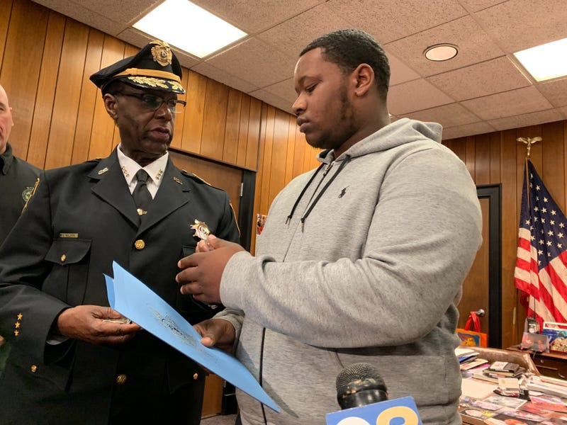 Sheriff Gilbert Wilson presents Kenney Smith with honorary coins for bravery.