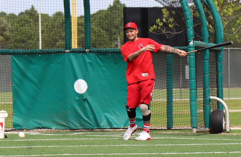 Catcher Yadier Molina assists in a drill with outfielders.