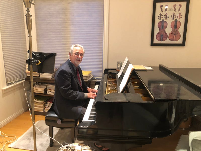 Bob Athayede sits at his piano.