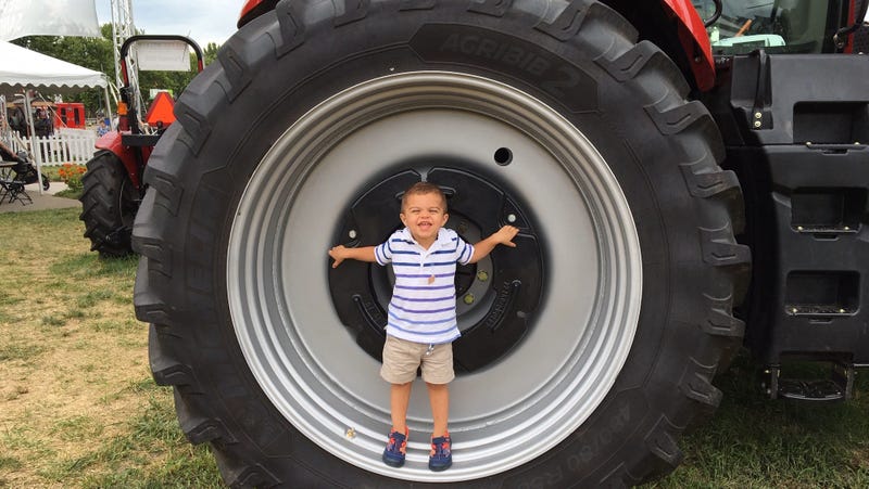 Little E.J. Becker stands inside a big tractor tire.