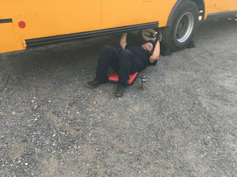 Mechanic inspects a school bus. 
