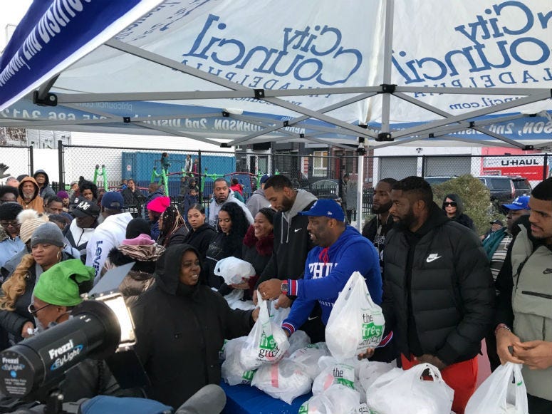 Philadelphia 76ers' Tobias Harris, Mike Scott, and James Ennis III giving out turkeys in South Philadelphia.