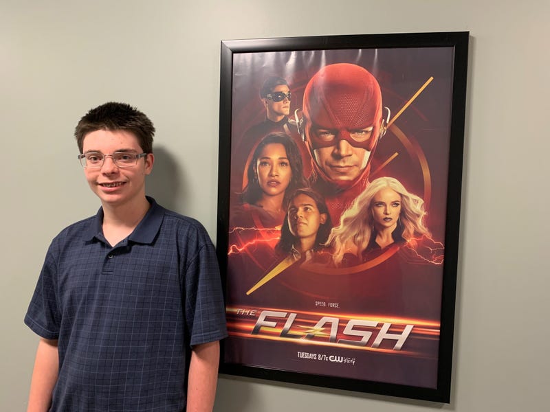 Michael stands next to a promotional poster for his favorite TV show, "The Flash," at the KYW broadcast center.