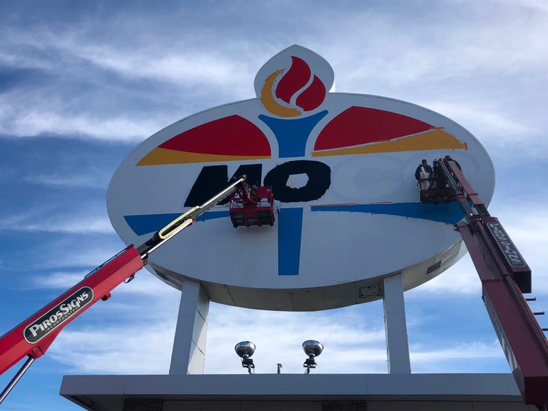 Workers repaint the landmark Amoco sign near Forest Park