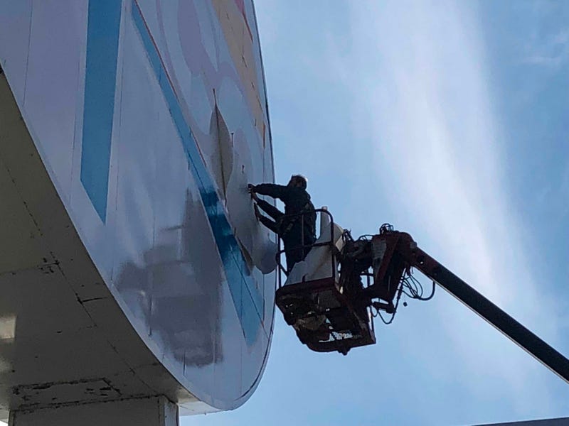 Workers repaint the landmark Amoco sign near Forest Park