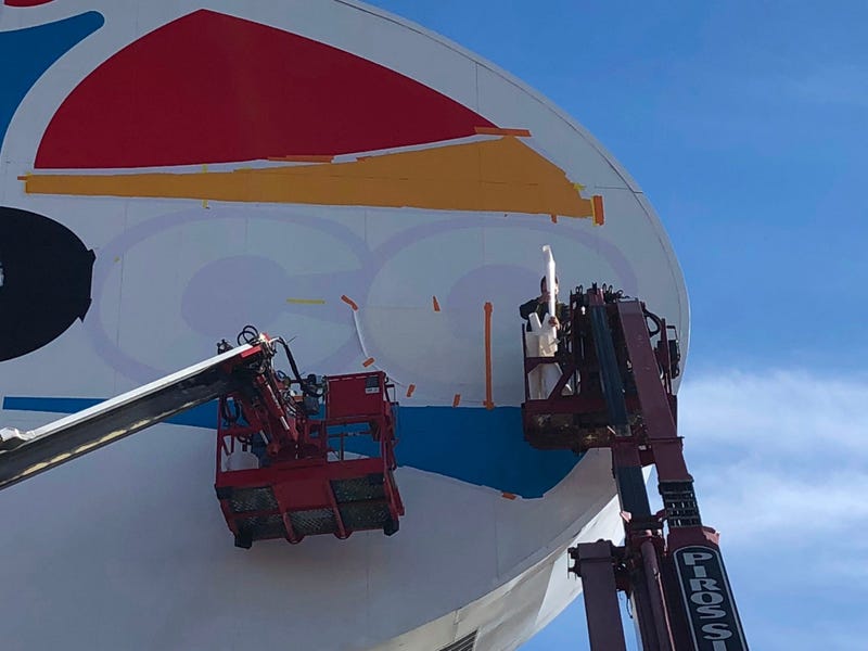 Workers repaint the landmark Amoco sign near Forest Park