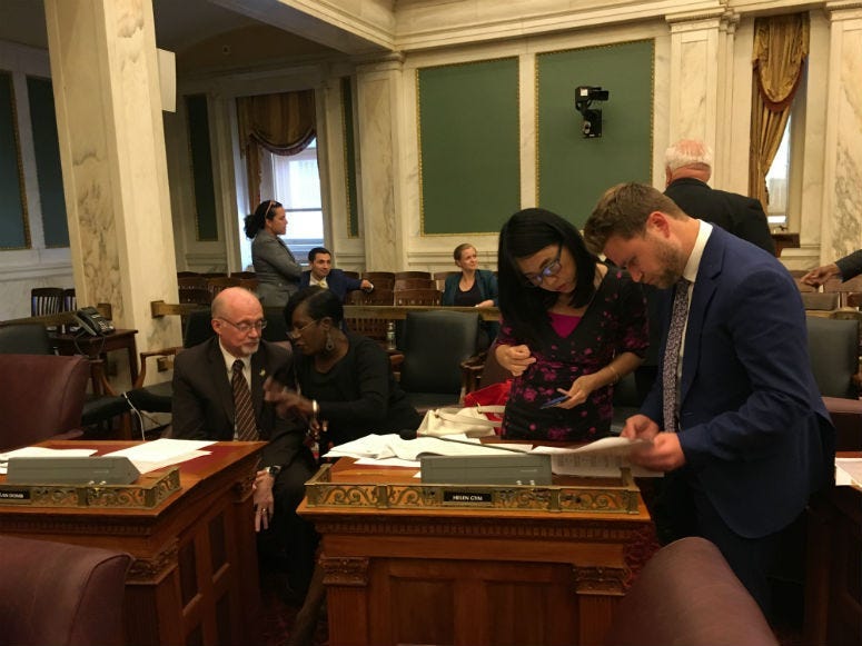 Council members Bill Greenlee and Cherelle Parker exchange thoughts on the budget while Coucilmember Helen Gym looks over the numbers with an aide.