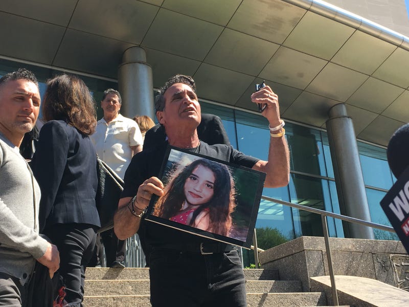 Karine Vetrano's father holds a picture of her outside of a sentencing hearing for her killer Chanel Lewis.