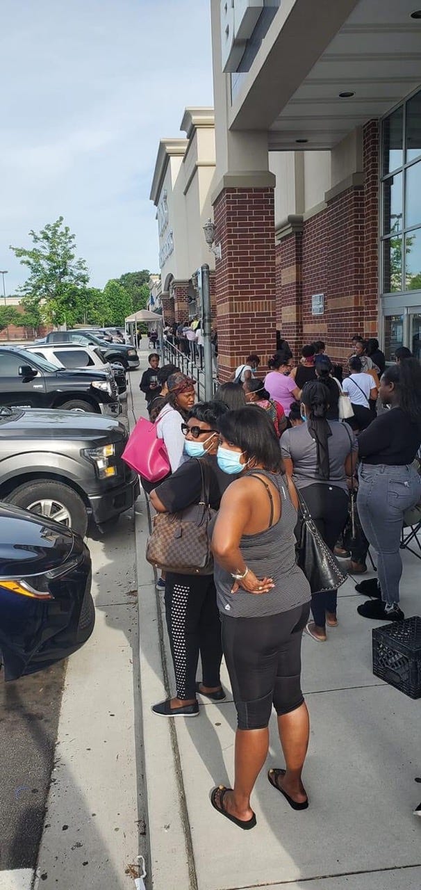 A long line extends outside the Ross store in McDonough GA as customers await their turn to enter