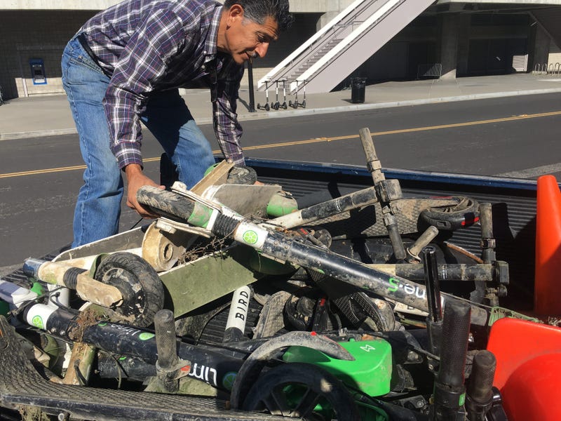 Roger Castillo, who monitors South Bay rivers, examines Bird scooters pulled from the Guadalupe River in April 2019.