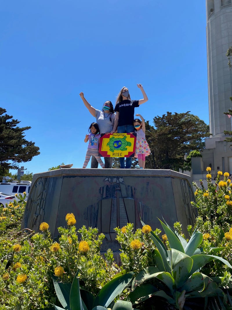 Mariposa Villaluna (left), Amy Anderson (right) and their kids celebrate the removal of San Francisco's Christopher Columbus statue.