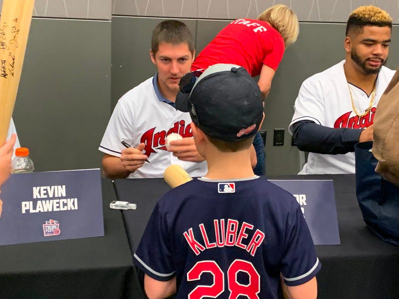 Trevor Bauer hands an autographed baseball to a young fan