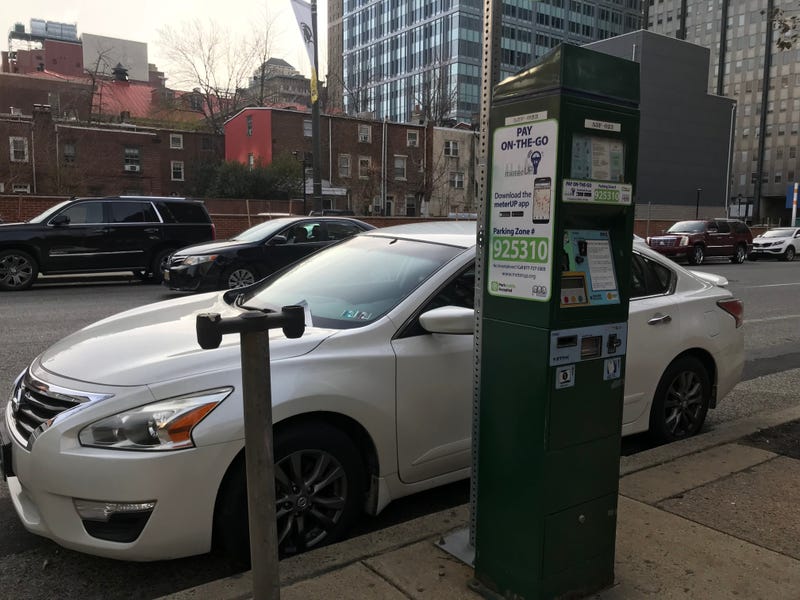 A Center City parking kiosk next to the remains of an old meter stand.