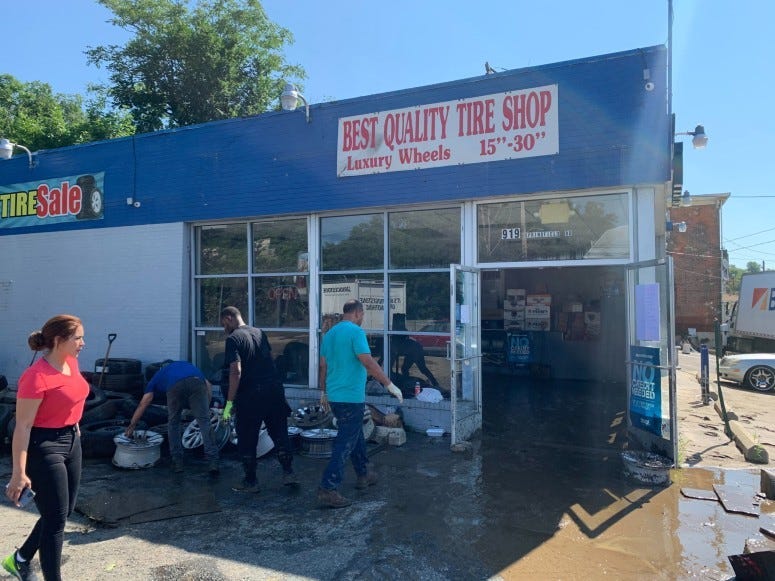 Best Quality Tire Shop employees cleaning up after flooding