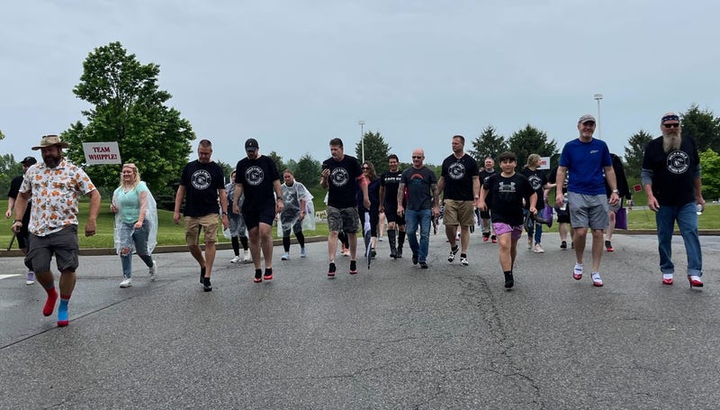 People taking part in the "Walk a Mile in Her Shoes" event in Collegeville, including men wearing heels.