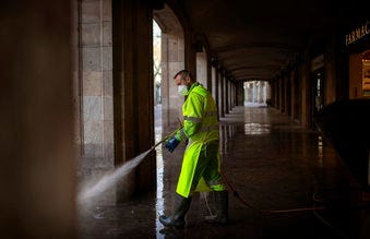 A worker disinfects the street to prevent the spread of COVID-19 in Barcelona, Spain, Thursday, March 19, 2020. For most people, the new coronavirus causes only mild or moderate symptoms.  (AP Photo/Emilio Morenatti)